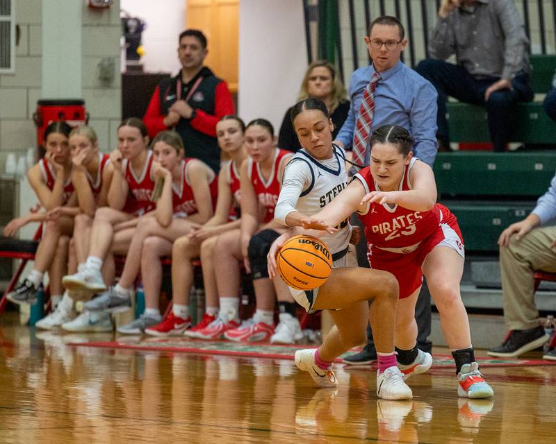 Mary Stisser (23) of Ottawa and Nia Harris (10) of Sterling reach for loose ball during Regional Championship game on Thursday, Feb. 19, 2026 in Sellett Gymnasium at L-P High School.