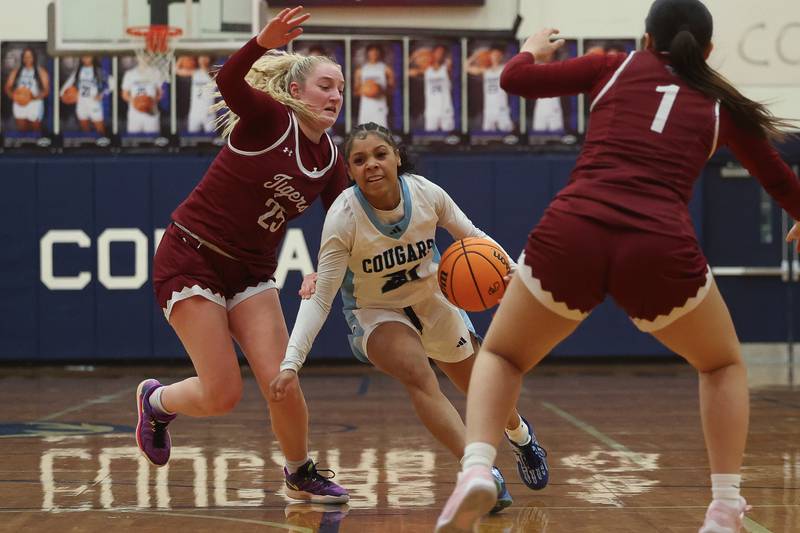 Plainfield South’s Tierra Abner drives around Plainfield North’s Sydney Scott on Thursday, Jan 9, 2025.