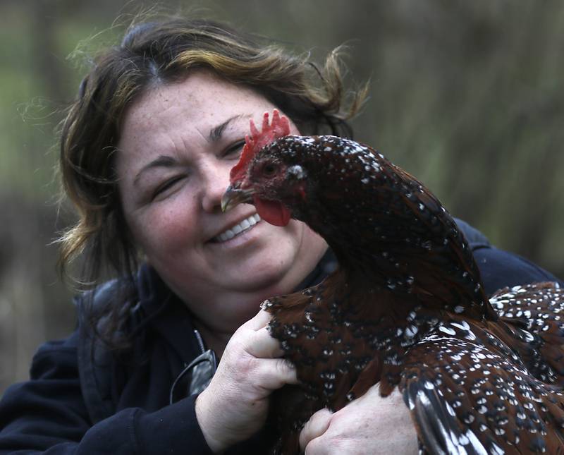Jessica Martell with one of her backyard chickens, Maui, on Wednesday, March 27, 2024, at her home on Half Mile Trail north of Crystal Lake.