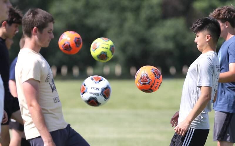 Sycamore soccer players get loose during warmups Wednesday, June 29, 2022, at summer boys soccer practice at the school.