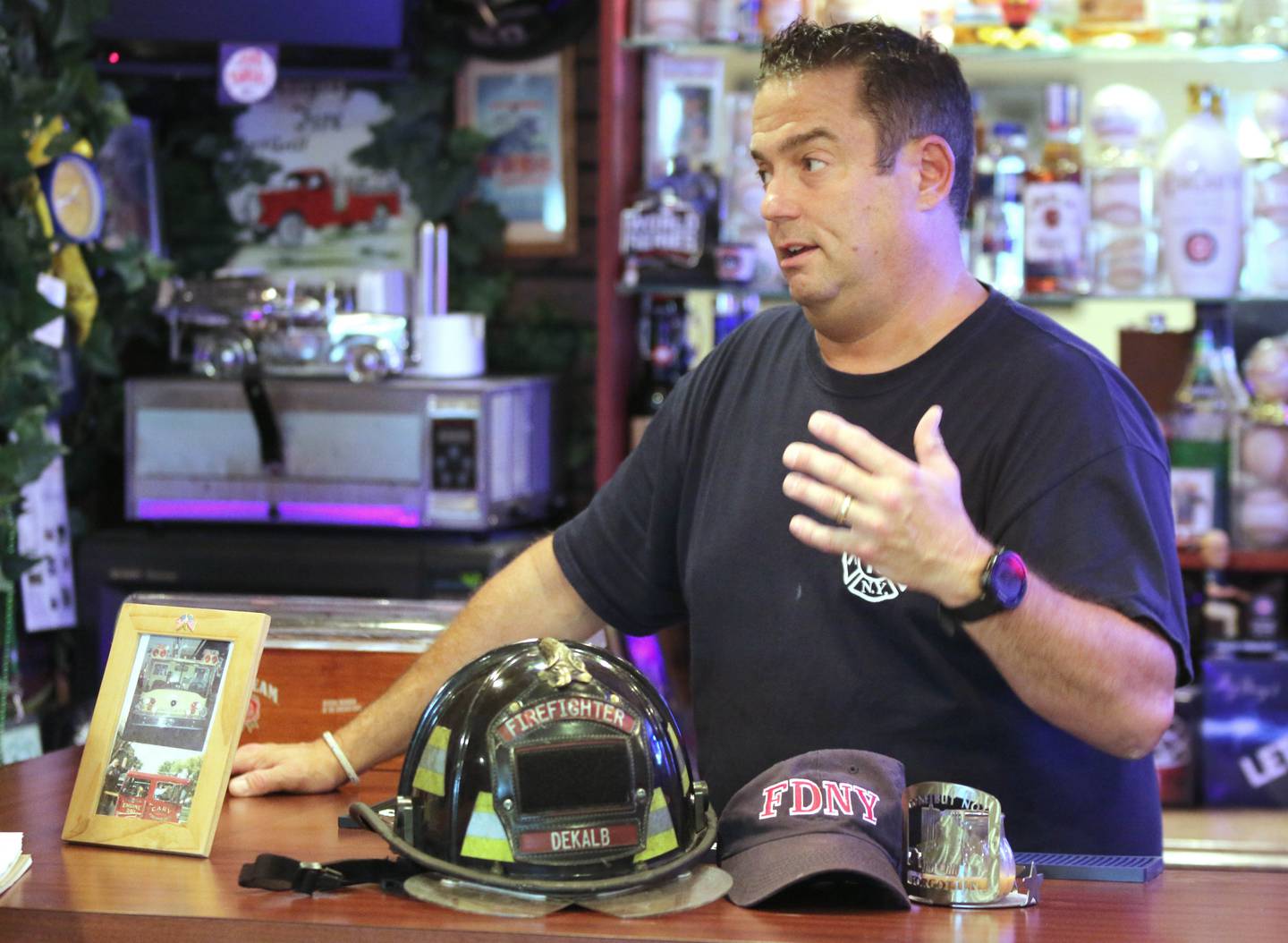 DeKalb firefighter/paramedic Pat Eriksen, surrounded by firefighter memorabilia from his family, talks Monday, Aug. 30, 2021, in his Sugar Grove home, about his cousin John Joseph Florio, a New York City firefighter from Engine Company 214 out of Brooklyn, who was killed while responding to the Twin Towers during the Sept. 11, 2001 terrorist attacks. This year marks the 20th anniversary of the tragedy.