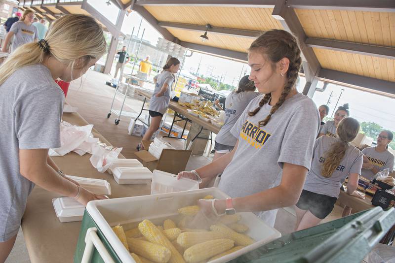 Finley Ryan (left) and Macie Lofgren put together delivery boxes for the annual Broil and Boil. Members of the Sterling High School swim and dive team, alongside groups from Sauk Valley College, Sterling wrestling, Woodlawn Arts Academy and Newman High School football team also helped with the fundraiser.