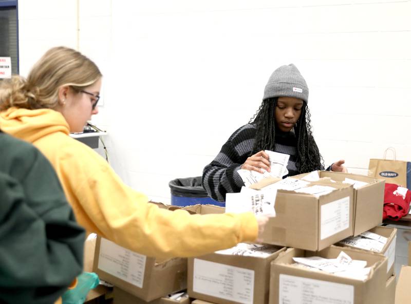 Downers Grove South High School junior Ellie Mazzeffi (left) and sophomore Bri Ndoko pack bags of food as part of the Blessings in a Backpack program on Monday, Nov. 13, 2023. The program will provide meals for 200 food insecure students in Downers Grove Grade School District 58 who won't have access to school meals during the upcoming Thanksgiving break.