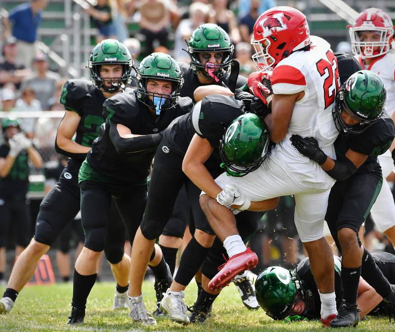 The Glenbard West defense gang tackles Marist's Marc Coy (22) during a game on Aug. 26, 2023 at Glenbard West High School in Glen Ellyn.