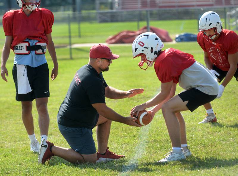 Oregon High School head coach Broc Kundert works with his quarterback during practice on Wednesday, Aug. 13, 2025 in Oregon.