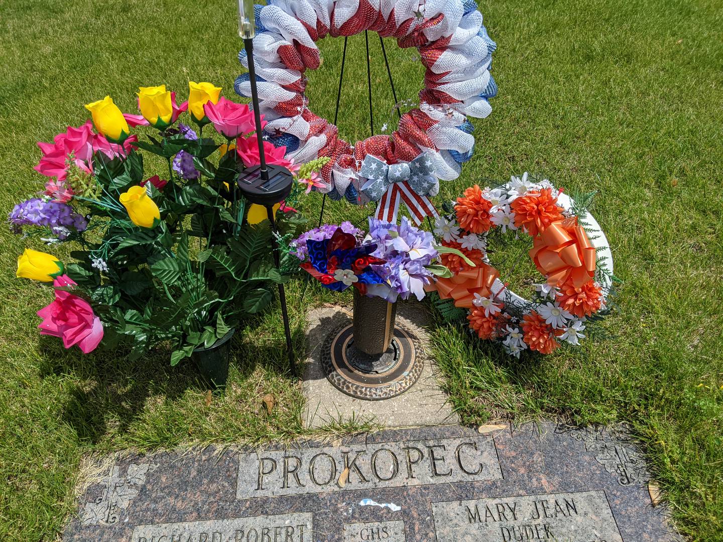 Richard and Mary Jean Prokopec, the parents of Sandy Meinke of Romeoville, are buried in Resurrection Cemetery in Romeoville. Their headstones have red, white, and blue decorations for Memorial Day. Meinke often visits this cemetery as many of her friends and family are buried there.