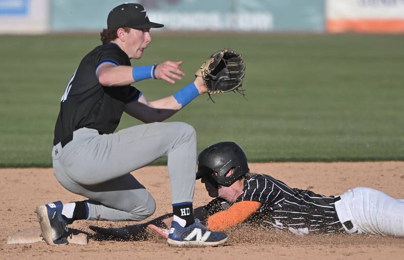 St. Charles East’s Sam Frausto steals second in the first inning as St. Charles North’s Jackson Spring waits for the throw in the third game of their inter-city series at Northwestern Medicine Field in Geneva on Tuesday, April 20, 2024.
