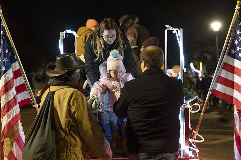 Valerie and Ryan Simon of Rock Falls help daughter Madison, 3, off of a horse-drawn carriage Sunday, Nov. 27, 2022 at Centennial Park in Rock Falls. The Simons took Madison and Hailey, 5, on a ride through the park to see the holiday displays of lights.