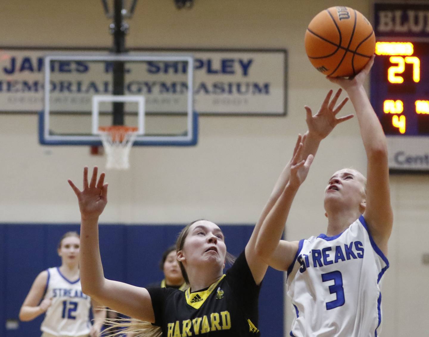 Woodstock's Emma Bierman drives to the basket against Harvard's Summer Jones during a Kishwaukee River Conference girls basketball game on Monday Jan. 12, 2026, at Woodstock High School.