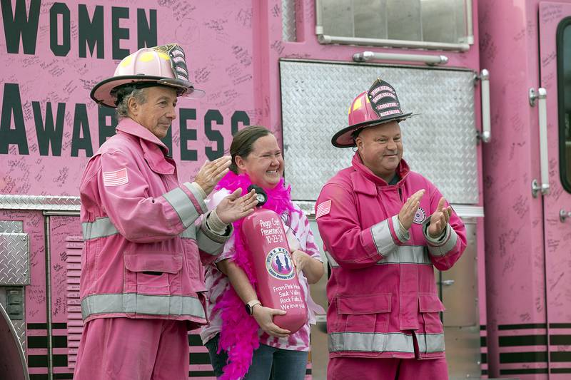 Craft is presented with a repurposed air tank Wednesday, Oct. 23, 2024, as a gift and show of support from Pink Heals of the Sauk Valley’s Frank Selmi (left) and Brian Tribley.