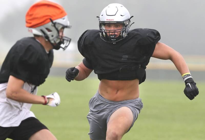 Kaneland’s Damian Wilson looks for someone to block during practice in the fog Wednesday, Aug. 9, 2023, at the school in Maple Park.