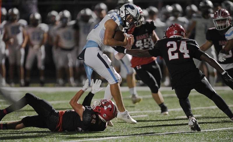 Maine South’s Michael Taylor holds the jersey of Prospect’s Brad Vierneisel as teammate Samuel Cooper helps bring down the quarterback in a Thursday night football game in Park Ridge on September 15, 2022.