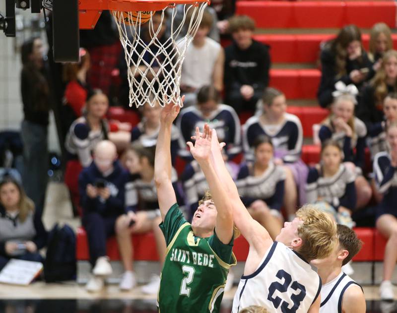 St. Bede's Kaden Nauman lets go of the ball under the hoop as Ridgeview's Carter Beck defends during the Route 17 Classic Tournament on Wednesday, Nov. 27, 2024 at Woodland High School.