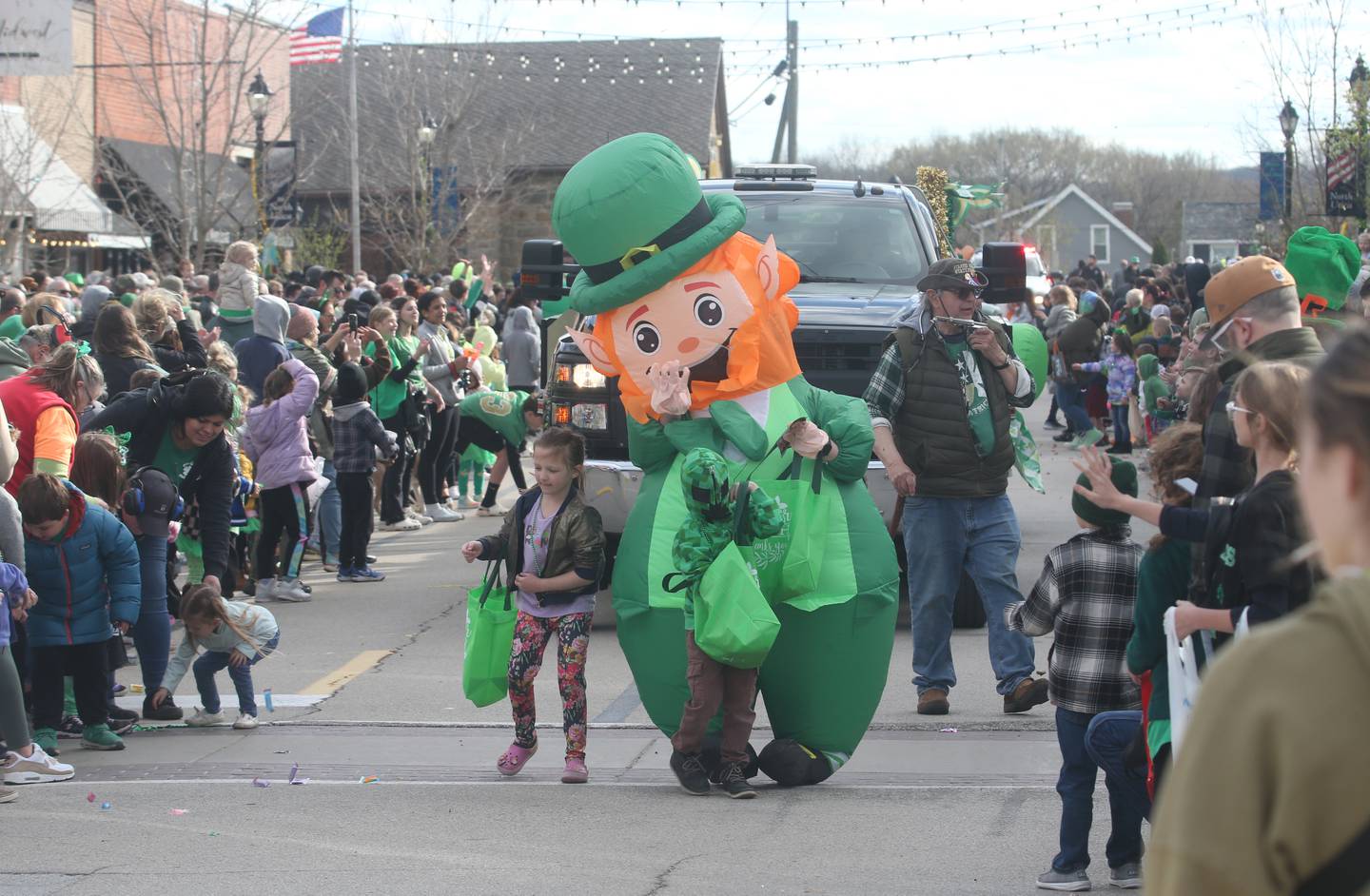 An inflatable leprechaun waves to the crowd during the St. Patrick's Day parade on Saturday, March 16, 2024 downtown Utica.