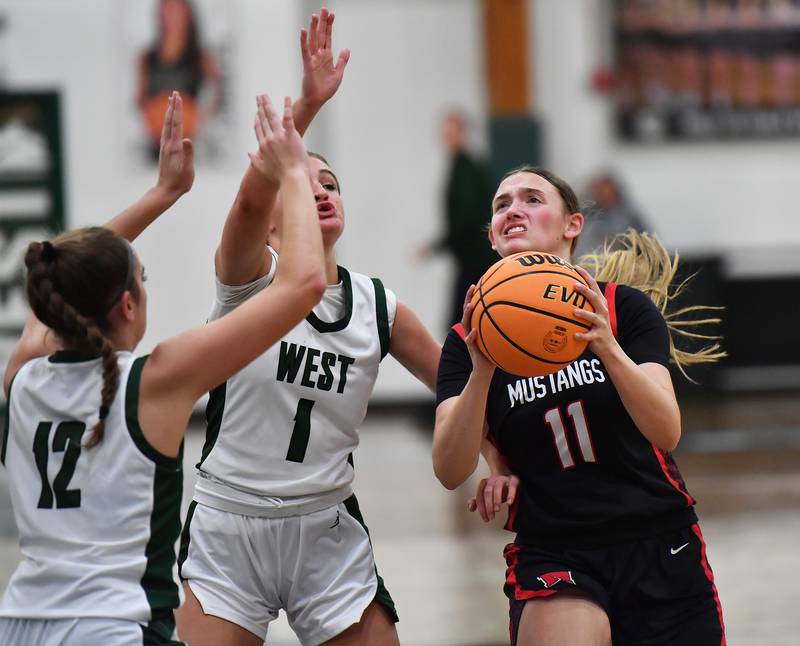 Mundelein’s Casey Vyverman (11) drives to the basket past Glenbard West’s Nina Hendricksen (1) and Lily Pones (12) during a Grow the Game Showcase game on January 2, 2026 at Glenbard West High School in Glen Ellyn.