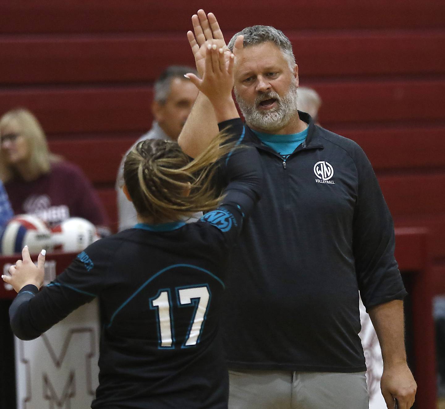 Woodstock NorthHead Coach Eric Schulze high fives Madison Sofie during a Kishwaukee River Conference volleyball match against Marengo Monday, Aug. 21, 2023, at Marengo Community High School.