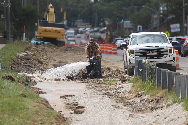 A worker opens up a fire hydrant as crews work on replacing water lines along East Ninth Street on Wednesday, August 21, 2024 in Lockport.