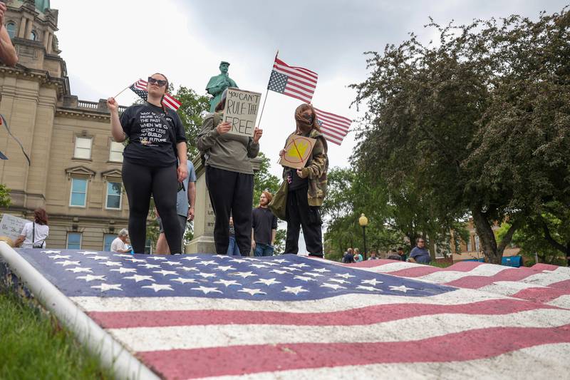 Protesters hold signs and American flags as approximately 500 people gathered at the Kankakee County Courthouse for a ‘No Kings’ rally in Kankakee on Saturday, June 14, 2025, to protest actions by President Donald Trump.