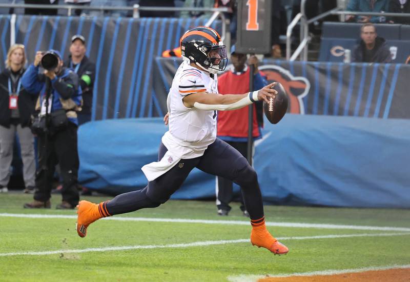 Chicago Bears quarterback Justin Fields crosses the goalie for a touchdown against the Arizona Cardinals during their game Sunday, Dec. 24, 2023, at Soldier Field in Chicago.