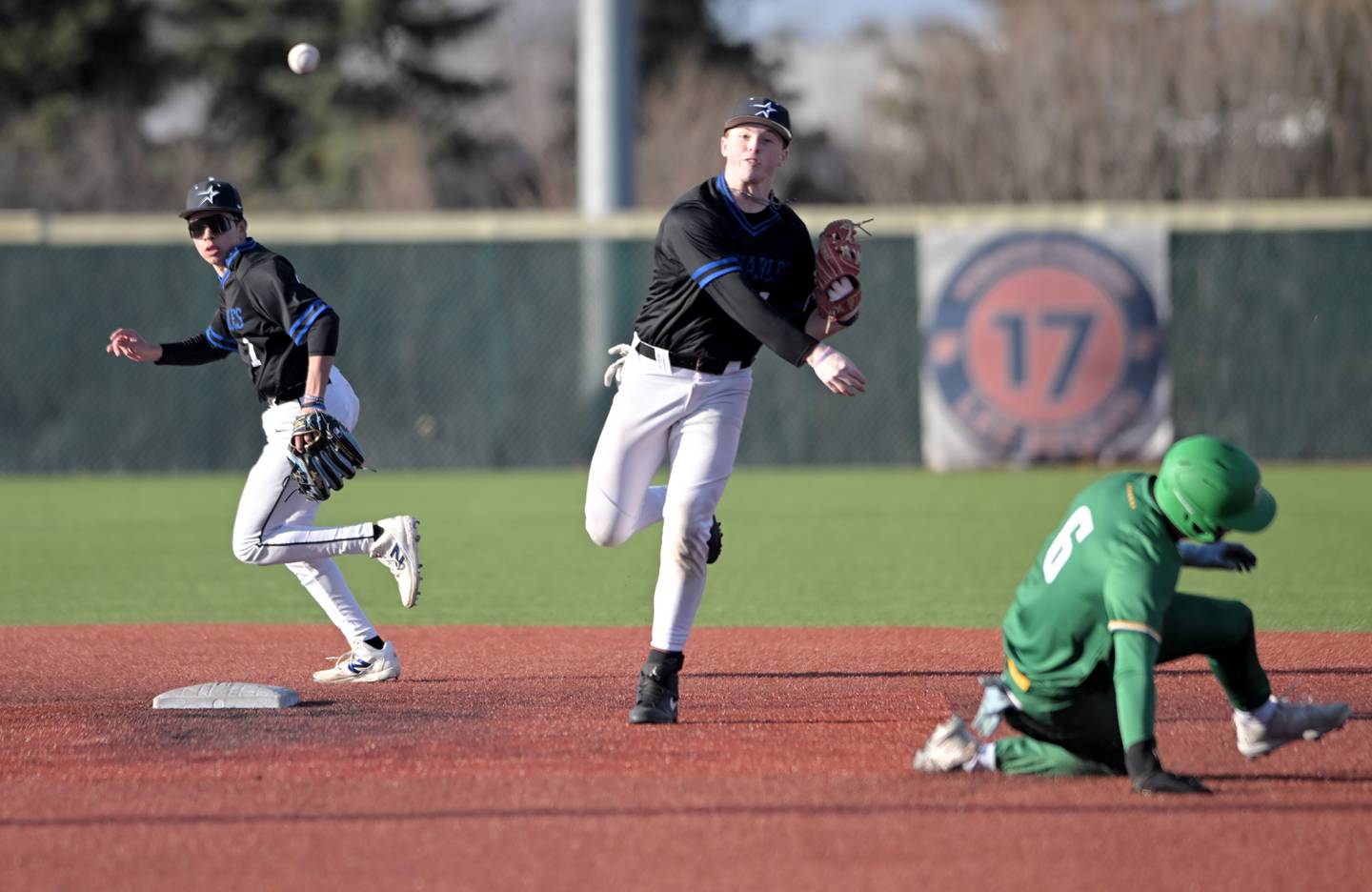 St. Charles North’s Mason Netcel throws to first after forcing out Providence Catholic’s Nate O'Donnell for the first out of a double play started by second baseman Nolan Macholz, left, in a baseball game at Wheaton College on Tuesday, March 25, 2025.