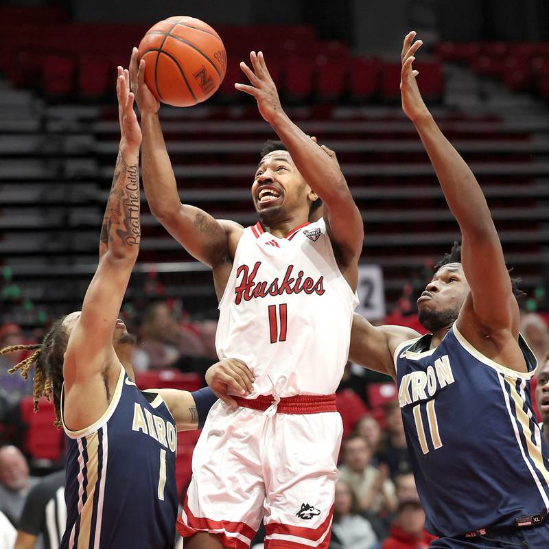 Northern Illinois' David Coit goes to the basket between two Akron defenders during their game Tuesday, Jan. 2, 2024, in the Convocation Center at NIU in DeKalb.