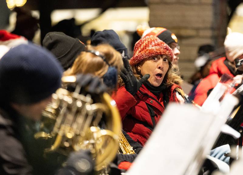 Batavia Community Band member Bettina Sailor of North Aurora sings along to the bands performance of “Rudolph the Red Nosed Reindeer” during the Celebration of Lights at the Batavia Riverwalk on Sunday, Dec. 1, 2024.