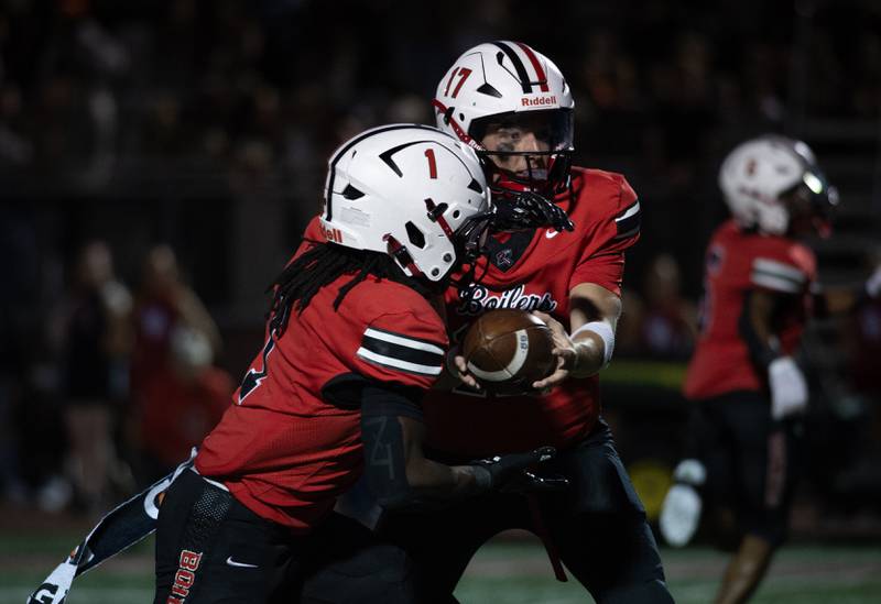 Bradley-Bourbonnais' Ellis Johnson hands the ball off to Kyren Edmon in a game against T.F. North on Friday, August 29, 2025.