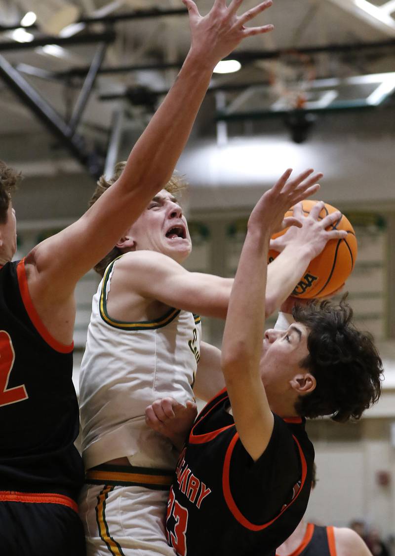 Crystal Lake South's Nick Stowasser (center) drives to the basket between McHenry's Caleb Jett (left) and Marko Stojich (right) during a Fox Valley Conference basketball game on Friday, Jan. 31, 2025, at Crystal Lake South High School.