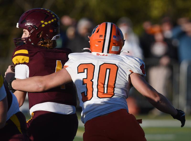 Joe Lewnard/jlewnard@dailyherald.com
Byron’s Nick Ingram closes in on Montini quarterback Gaetano Carbonara for a sack during the Class 3A semifinal game in Lombard Saturday.