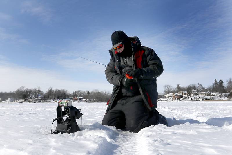 Trevor Janes, who owns Wet N Wild Outfitters, ice fishes Friday, Feb 3. 2023, on Petite Lake near Fox Lake.