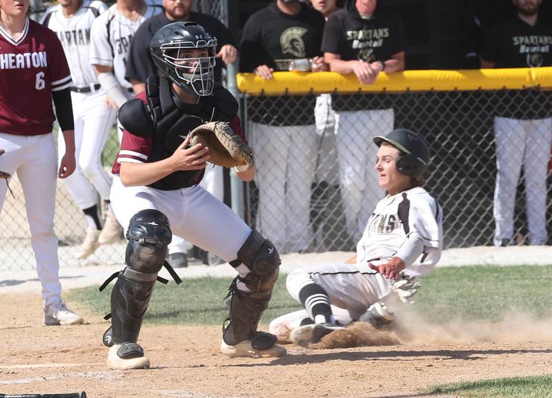 Sycamore's Collin Severson slides in with the first run of the game during their Class 3A sectional semifinal against Wheaton Academy Wednesday, May 29, 2024, at the Sycamore Community Sports Complex.
