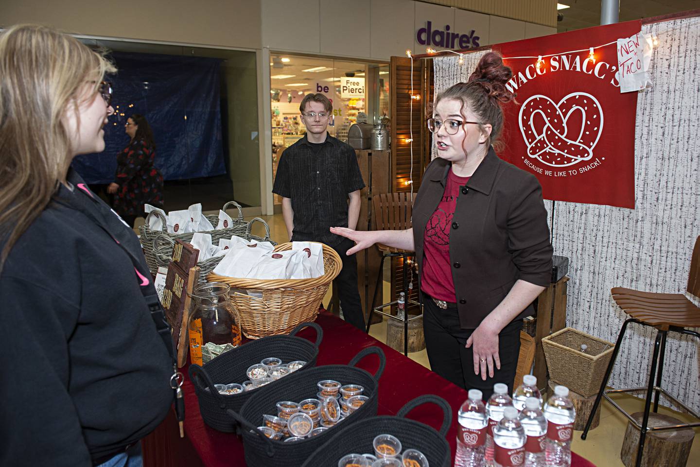 Molly Riffle of Morrison, the brains behind WACC’s SNACC’s, describes her sweet and savory pretzels to customer Autumn Nelson of Rock Falls. Riffle offers up flavors of taco, garlic and white and milk chocolate.