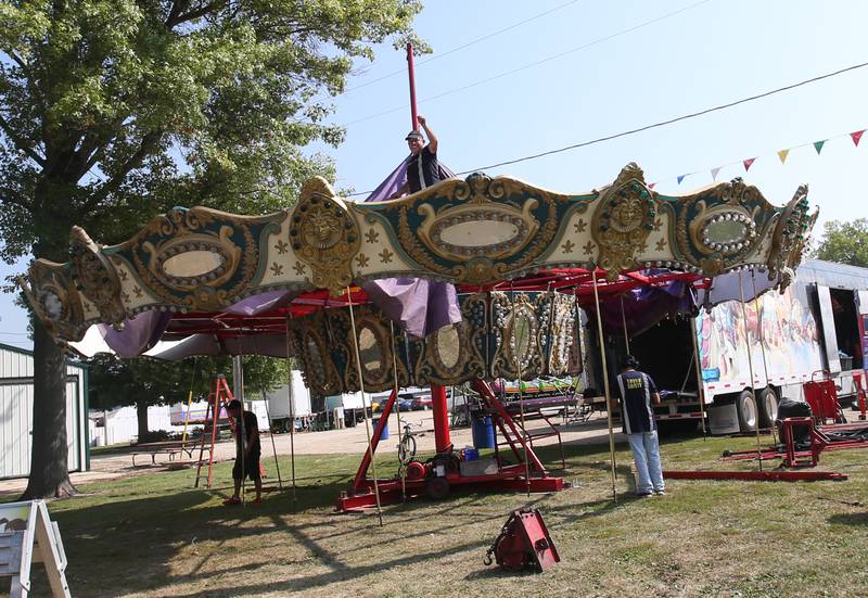 North American Midway Entertainment carnival workers set up the carousel ride for the 168th annual Bureau County Fair on Tuesday, Aug. 22, 2023 in Princeton. The fair runs Wednesday through Sunday.