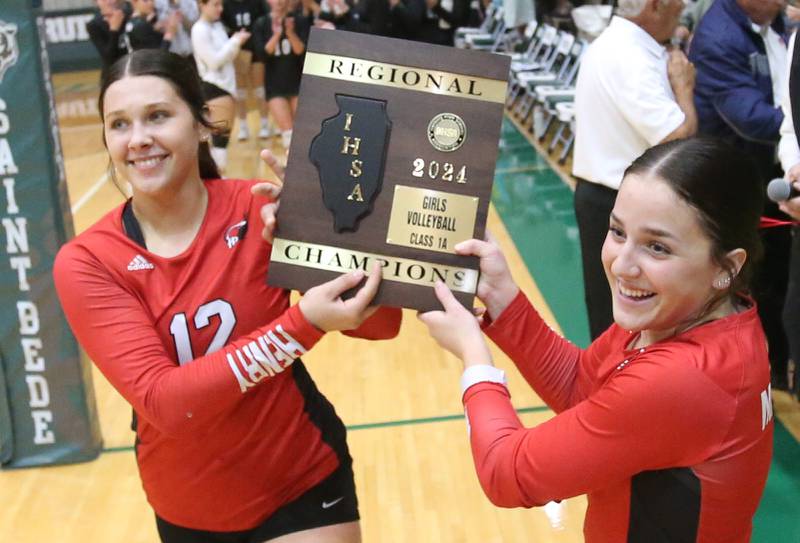 Henry-Senachwine's Kaitlyn Anderson and teammate Lauren Harbison carry the Class 1A Regional plaque after defeating St. Bede on Thursday, Oct. 31, 2024 at St. Bede Academy.