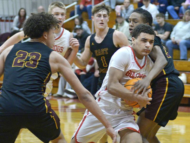 Streator’s Layzeric Moton works to get past East Peoria’s QuintonKitt and BJ Nichelson on a drive to the basket during the 1st period Wednesday at Streator.