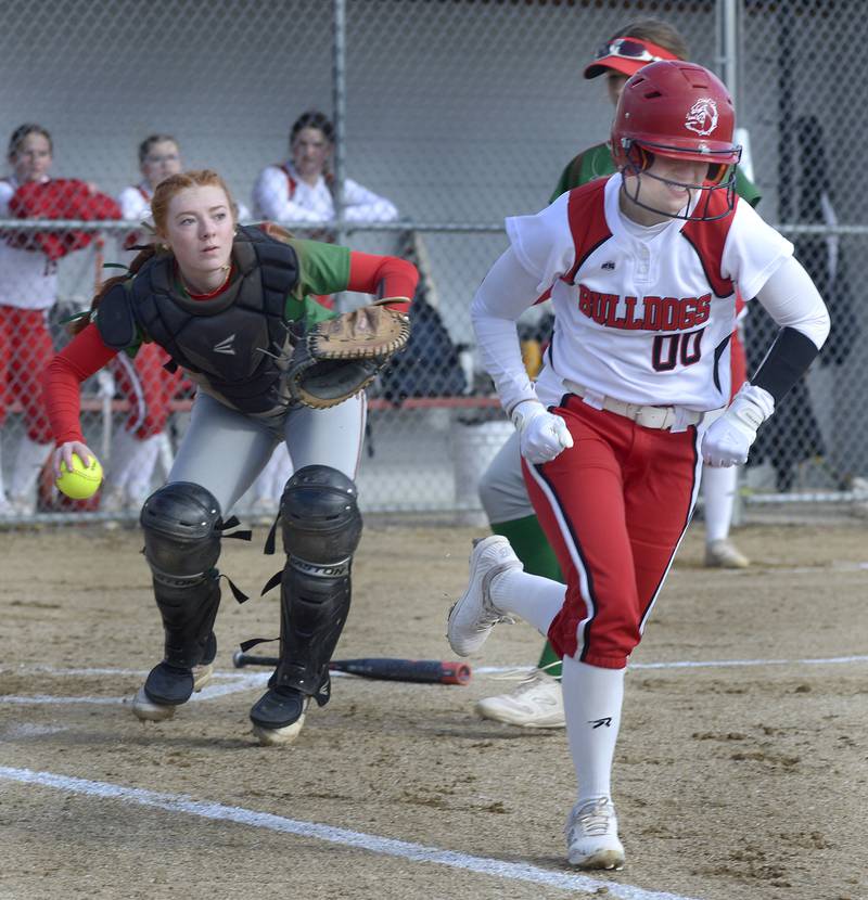 Streator’s Lily Kupec (00) runs to first on a sacrifice bunt as La Salle-Peru catcher Addison Duttlinger sets to throw in the home half of the first inning Wednesday, March 27, 2024, in Streator.