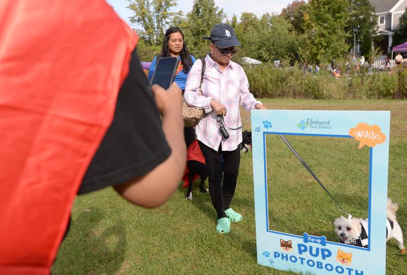 Tess Ongos of Chicago gets her dog "Boba" picture taken as part of the dog costume contest during the Elmhurst Park District Family Fall Fest Saturday, Oct. 5, 2024.