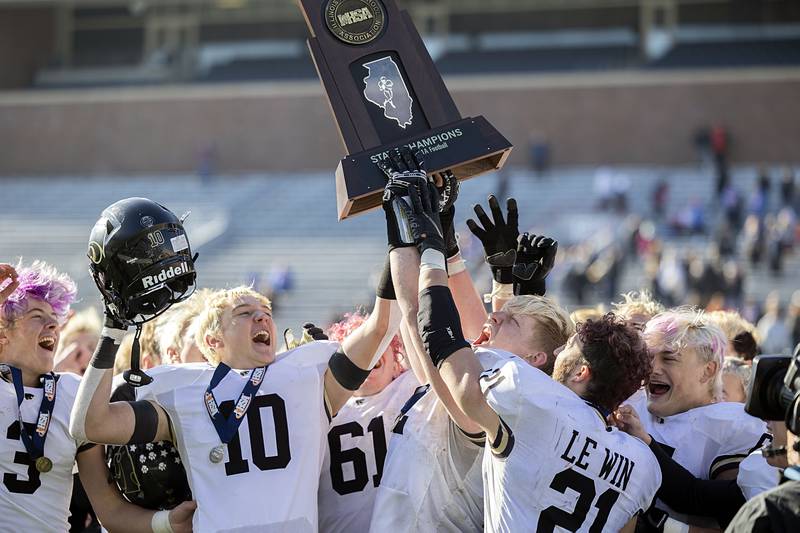 The Lena-Winslow Panthers hoist their class 1A IHSA football championship trophy after defeating Camp Point Central 30-8 in Champaign Friday, Nov. 25, 2022.