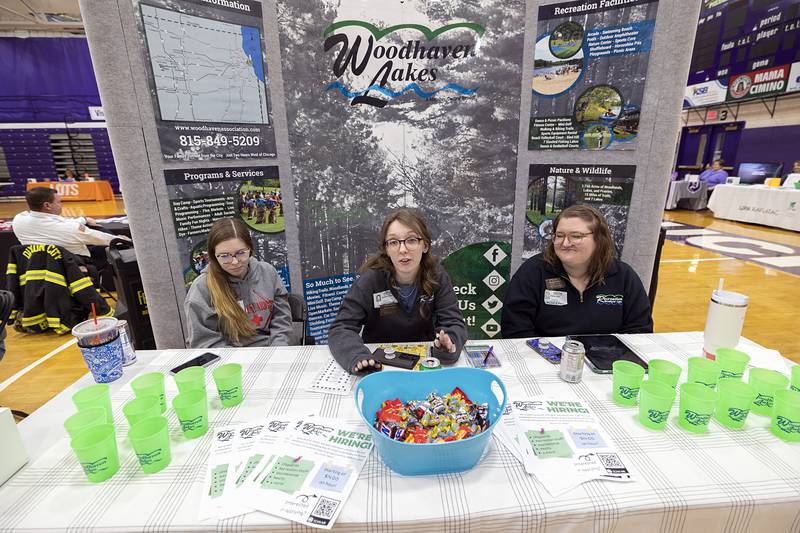 Woodhaven Lakes employees Faith Schafer (left), Katie Kwarta and Emma Lipka talk about jobs the recreation community has to offer Wednesday, March 13, 2024. Woodhaven was one of dozens of local businesses and organizations who set up a booth at Discover Dixon’s career fair.