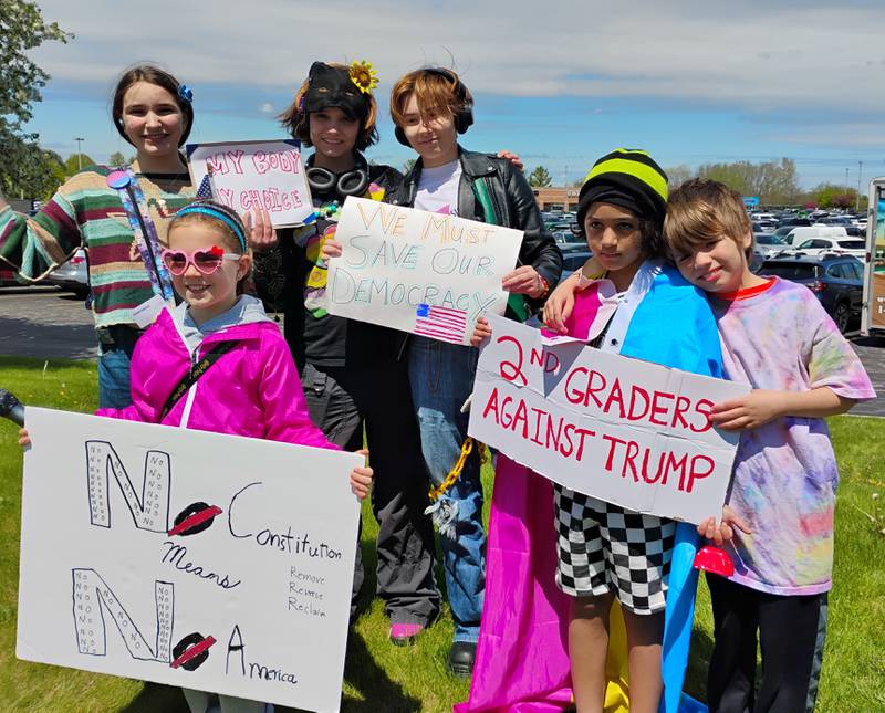 Amber Dipenbrock (left), Max Collum, Q Eddy stand with Brynn Hockey, (left front) Alex Polk and Arlo Cullum Saturday, May 3, at a Hands Off!! rally in St. Charles.
