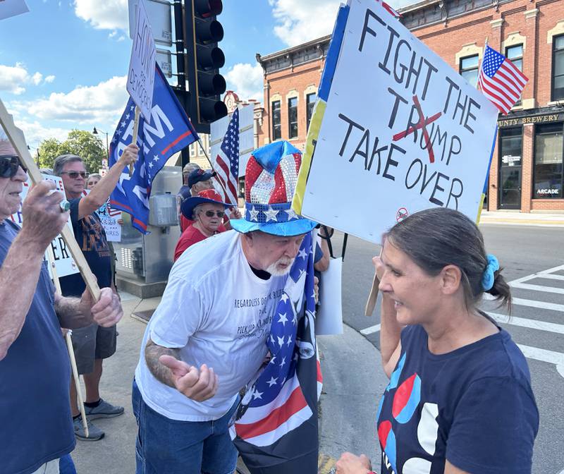 Trump supporter Gary Schrimpsher (center) talks with Indivisible of Ogle County's Jan Buttron at the "Workers Over Billionaires" rally in downtown Oregon on Monday, Sept. 1, 2025. About 125 people carried signs critical of Trump's policies and actions while around 10 were there in support of the president.