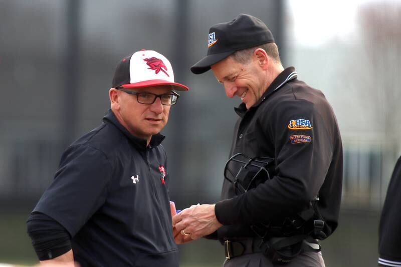 Huntley’s head coach Andy Jakubowski chats up the umpires between innings against Jacobs in varsity baseball Wednesday at Huntley.