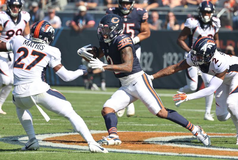 Chicago Bears wide receiver DJ Moore catches a pass between Denver Broncos cornerback Damarri Mathis and cornerback Pat Surtain II during their game Sunday, Oct. 1, 2023, at Soldier Field in Chicago.