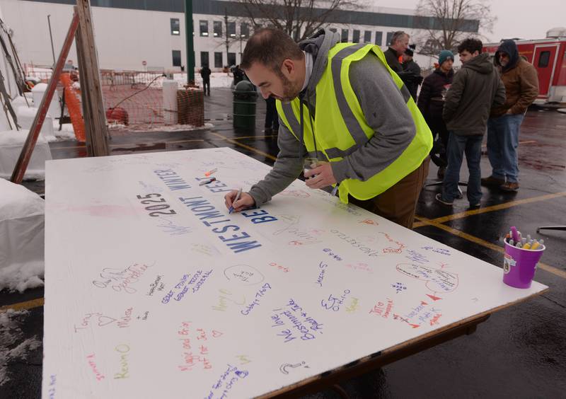 Westmont Park District's Assistant Director Joel Hymen adds his signature to the Winter Beer Festival sign Saturday, Feb. 15, 2025.