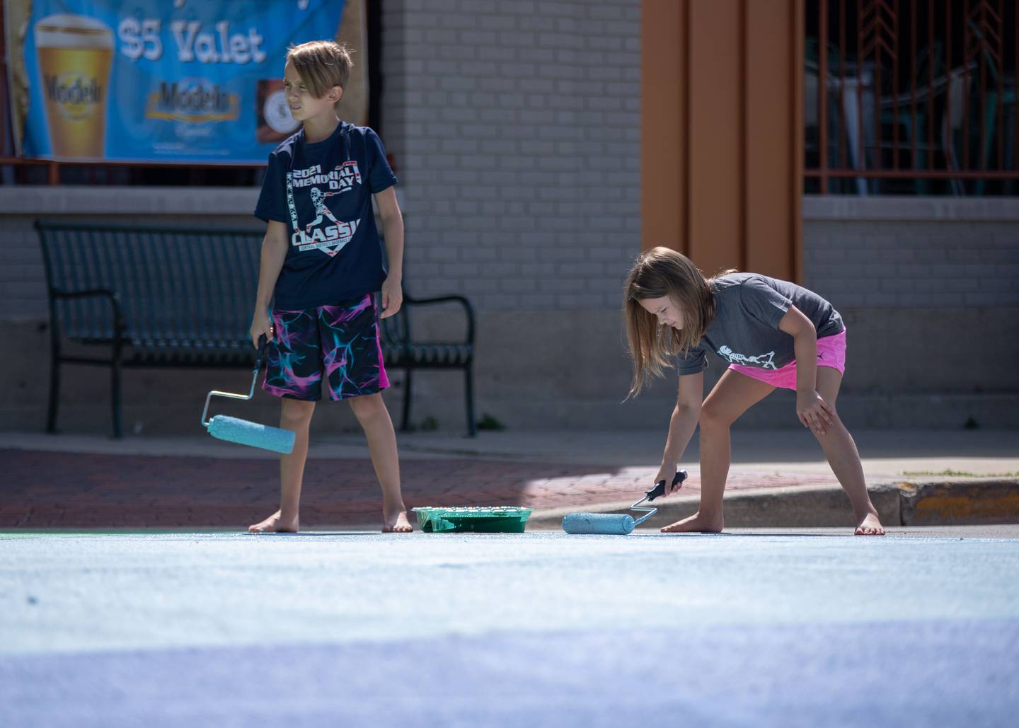 Lucas, 9, left, and Penelope, 7, Kunz of St. Charles paint the intersection of Riverside Avenue and Walnut Street in St. Charles at the Paint the Riverside event hosted by the St. Charles Arts Council on Saturday, July 30, 2022.