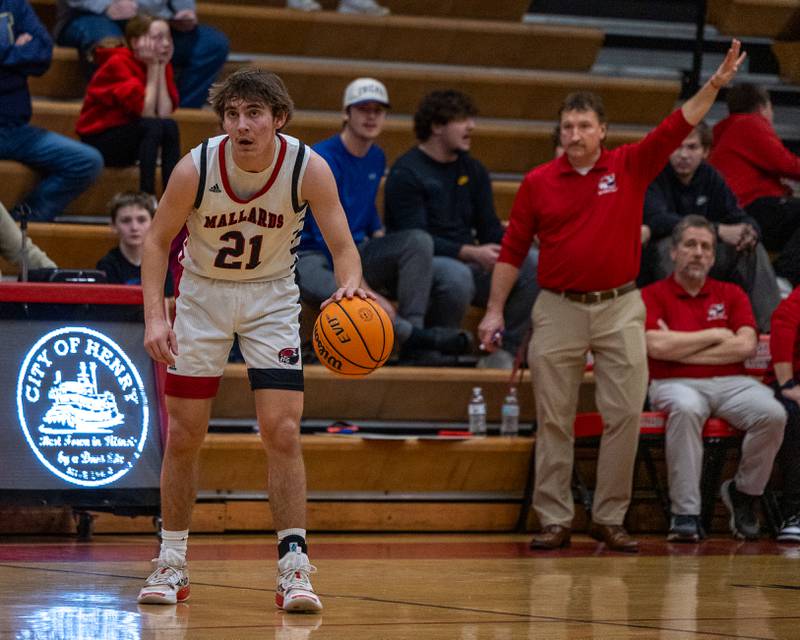 Henry-Senachwine's Carson Rowe (21) dribbles ball looking up at scoreboard as Head Coach Randy Westerdahl calls play on Friday, Feb. 13, 2026 at Henry-Senachwine High School in Henry.