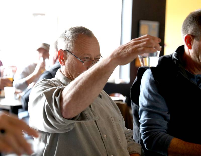 Judge Dan Mann looks at water clarity of one of the samples in the annual Kane County Water Association's annual water-tasting contest at Global Brew in St. Charles on Thursday, Dec. 21, 2023.