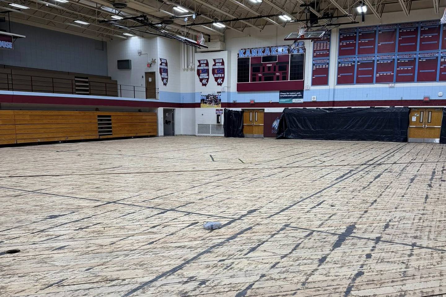 The Kankakee High School gym floor was removed following damage from the March 10 storms, showing the base layer of flooring in a post on April 1, 2026. Some areas of the subfloor have messages from the past.