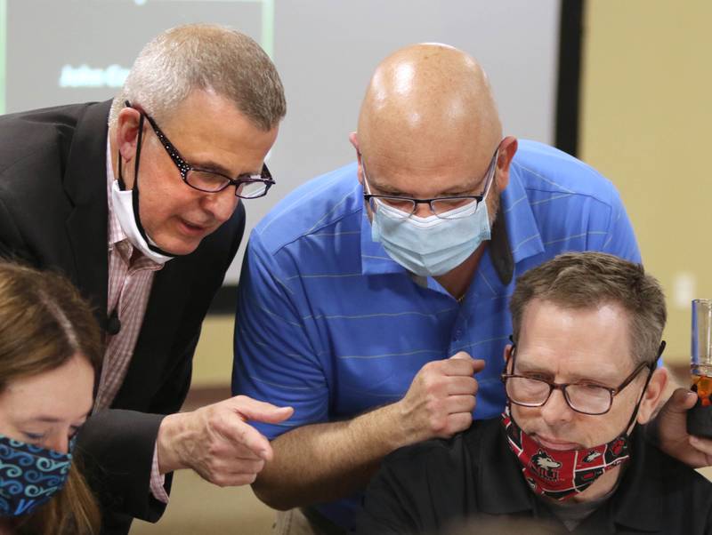 DeKalb mayoral candidate Cohen Barnes, (center) State Rep. Jeff Keicher, R-Sycamore and Faranda's owner Bill McMahon discuss the numbers Tuesday as returns begin to come in during an election night party at Faranda's Banquet Center in DeKalb.