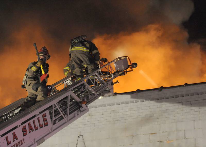 La Salle firefighters use their aerial truck to knock down flames above Skoogs Pub & Grill on Sunday, May 10, 2015 downtown Utica.